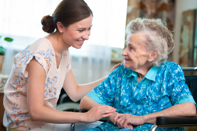 senior woman assisted by a female caregiver